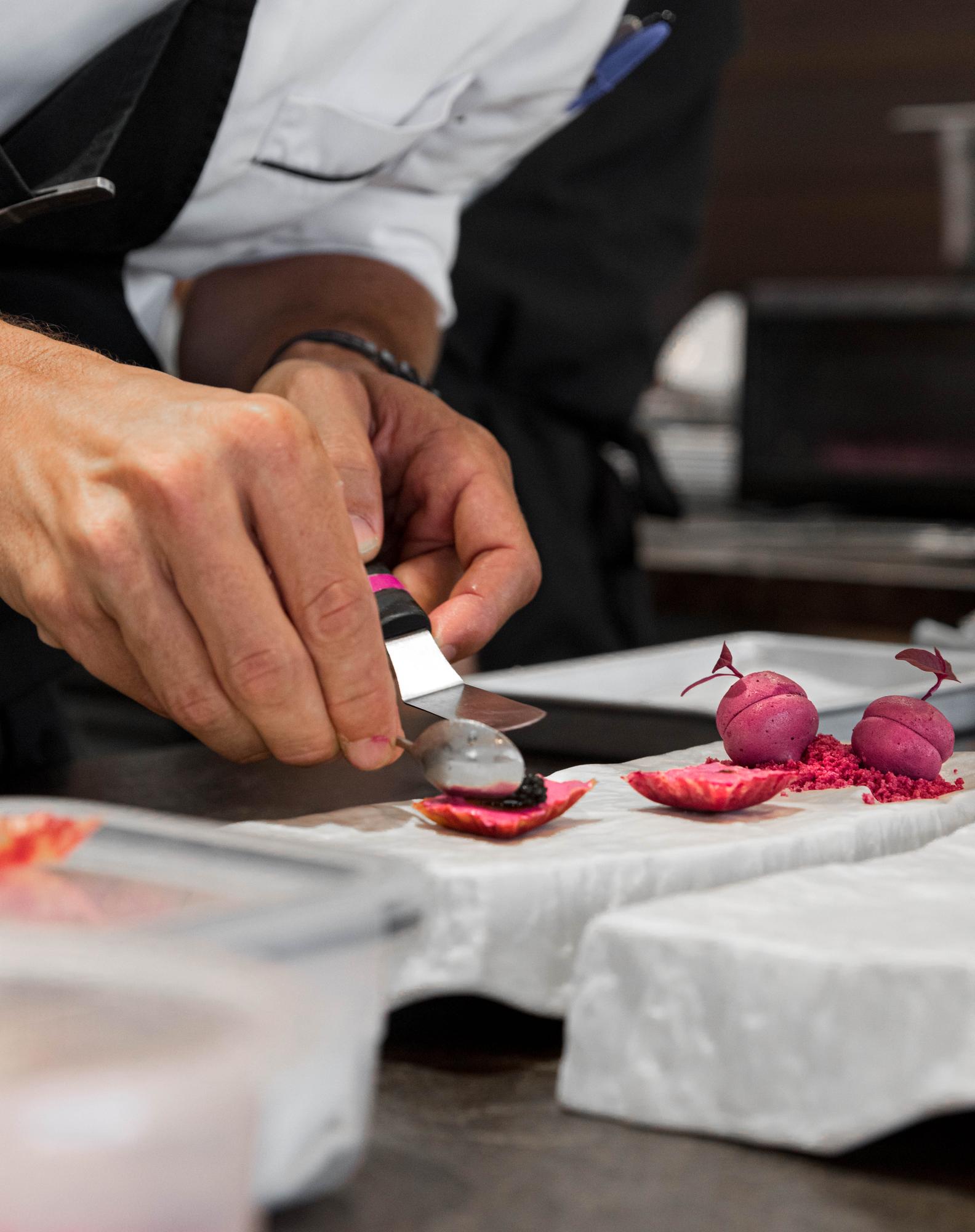 Chef demonstrating knife technique to attendee
