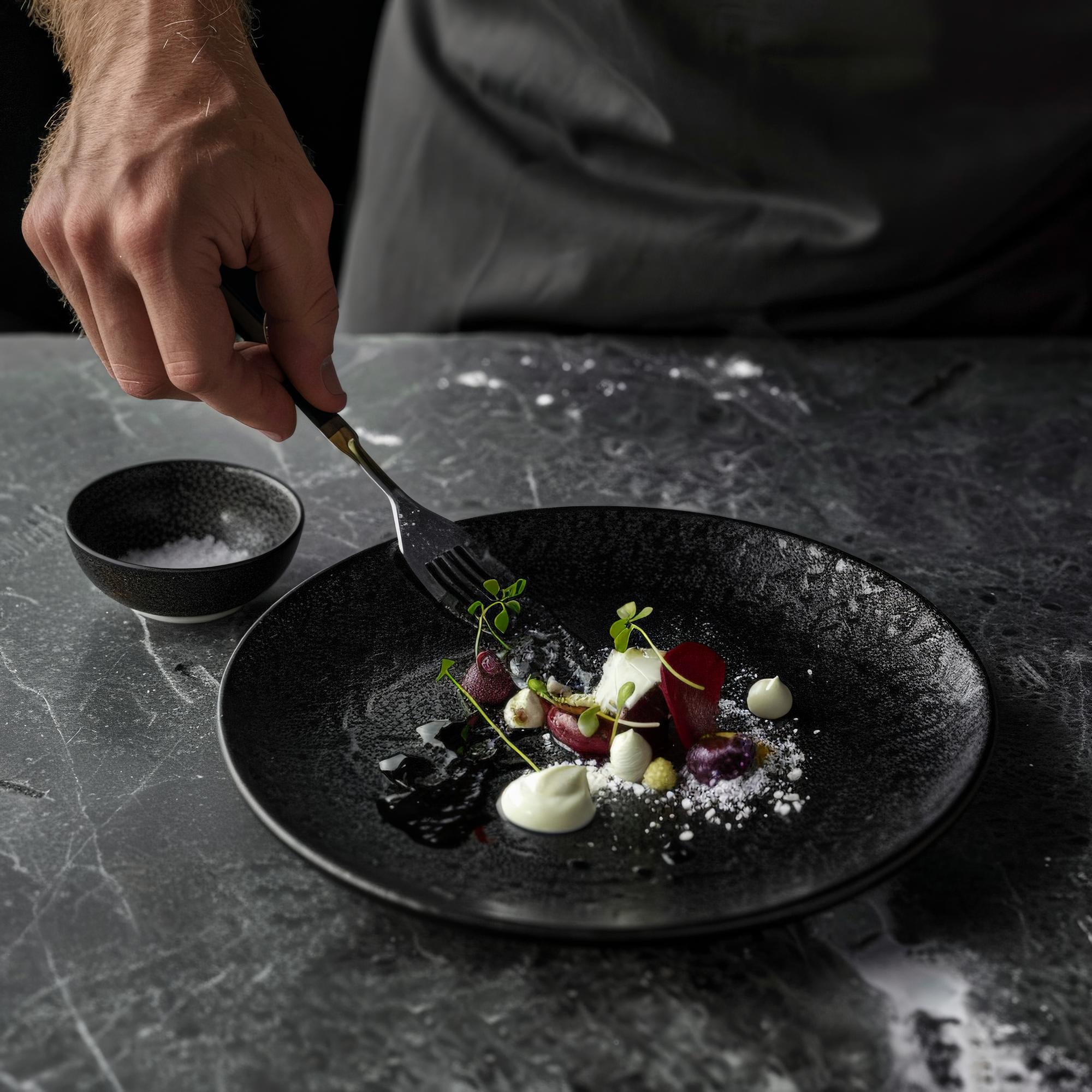 Chef arranging plated dish on slate